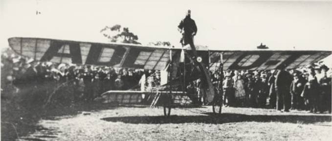  First flight from Melbourne to Sydney showing pilot Maurice Guillaux standing on a Bleriot monoplane with a 50 horsepower Gnome engine, Wangaratta, July 1914 [picture].