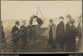 Darge, Algernon, 1878-1941. Maurice Guillaux in his Bleriot XI monoplane holding aerial mail bag at the Agricultural Society's show grounds before flying to Sydney on first air mail delivery, Melbourne, 16 July 1914 [picture]